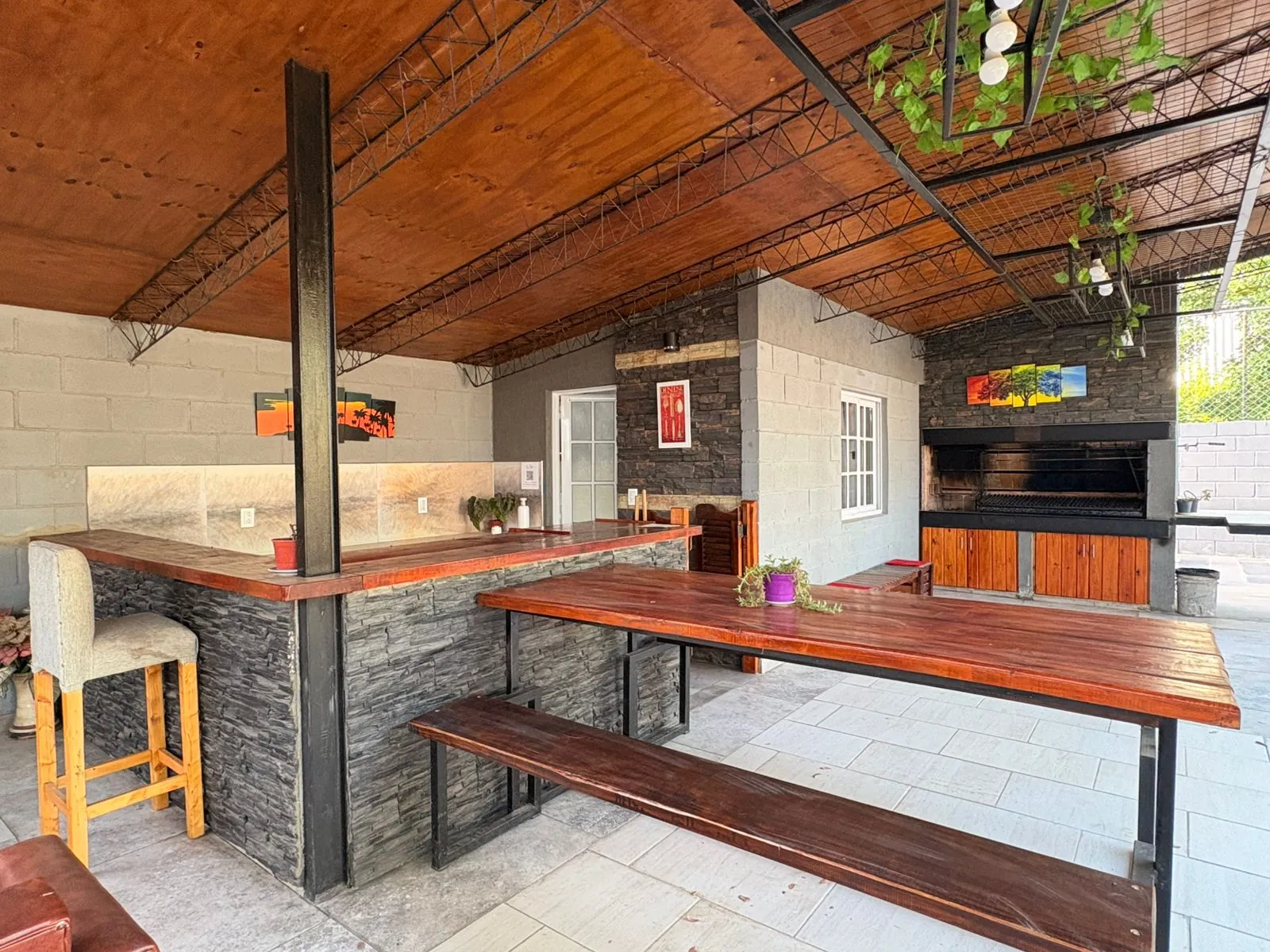 Quincho con barra, mesa de madera y parrilla