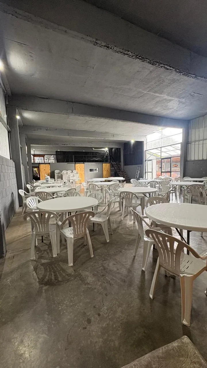 Salón cerrado con mesas redondas y sillas